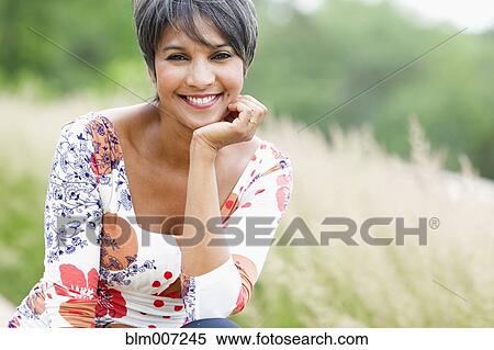 Stock Photography - Smiling mixed race woman in field. Fotosearch