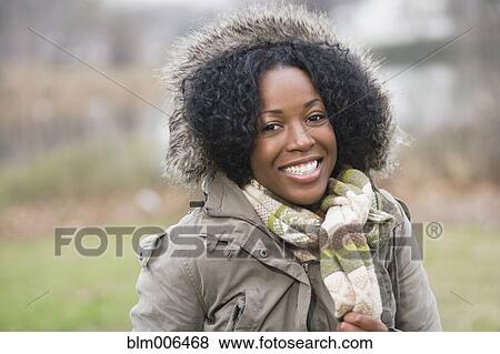 Smiling mixed race woman in fur-hooded coat View Large Photo Image Stock Photo - Smiling mixed race woman in fur-hooded coat. Fotosearch