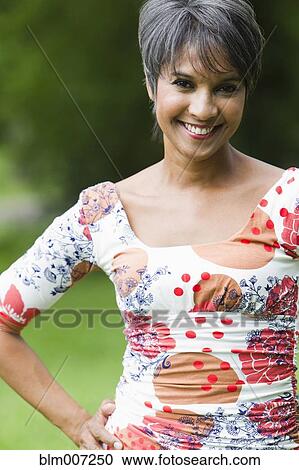 Stock Image - Smiling mixed race woman with hands on hips. Fotosearch