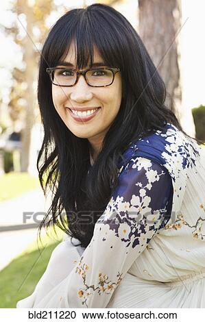 Smiling woman sitting outdoors View Large Photo Image Stock Image - Smiling woman sitting outdoors. Fotosearch