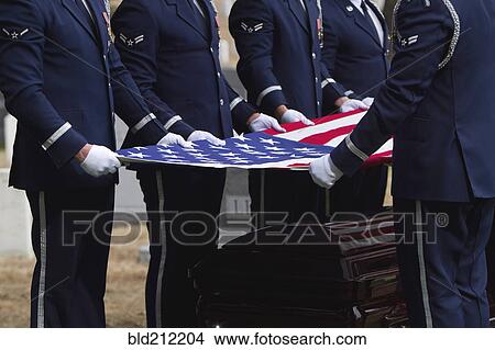 Picture - Soldiers folding flag at military funeral. Fotosearch