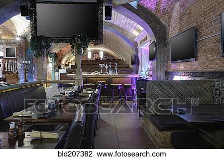 Stock Image - Sports bar and restaurant interior with screen and TVs on walls. Fotosearch