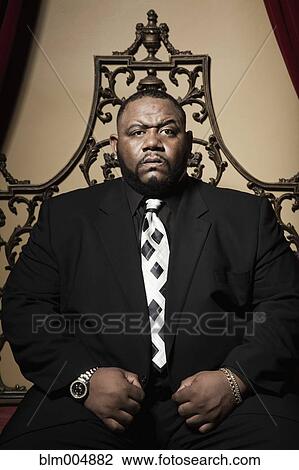 Stern African man sitting in ornate chair View Large Photo Image Stock Image - Stern African man sitting in ornate chair. Fotosearch