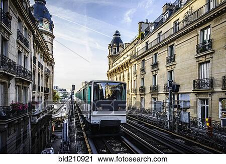 Stock Image - Streetcar passing between apartment buildings, Paris, France. Fotosearch