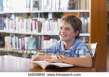 Stock Photography - Student smiling in library. Fotosearch