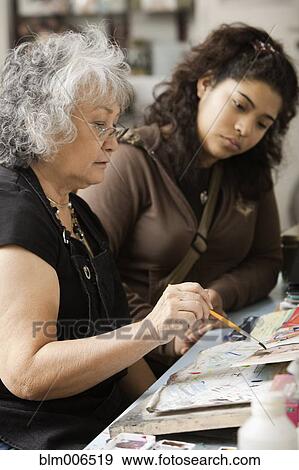 Student watching art teacher paint in classroom View Large Photo Image Stock Photo - Student watching art teacher paint in classroom. Fotosearch