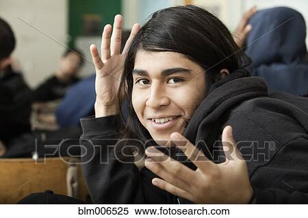 Stock Photography - Student waving hands in classroom. Fotosearch