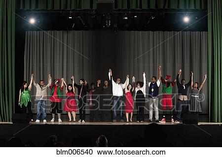 Stock Image - Students bowing on high school stage. Fotosearch