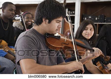 Stock Image - Students practicing in high school orchestra. Fotosearch