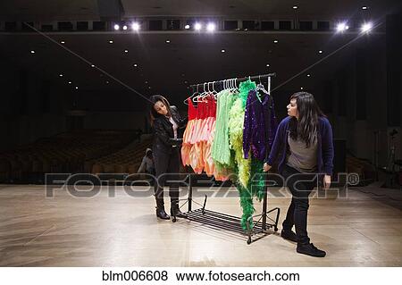 Stock Photo - Students pushing rack on theater stage. Fotosearch