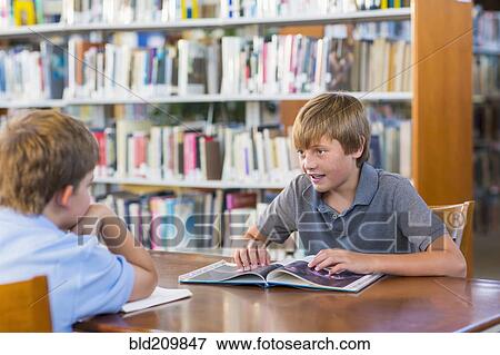 Stock Photo - Students reading together in library. Fotosearch