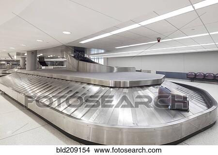 Picture - Suitcase on baggage claim carousel in airport. Fotosearch