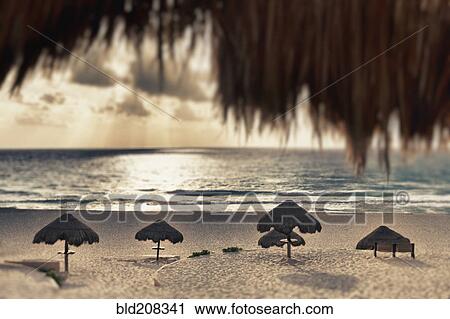 Stock Image - Sunrise viewed from the beach over the Caribbean. Fotosearch