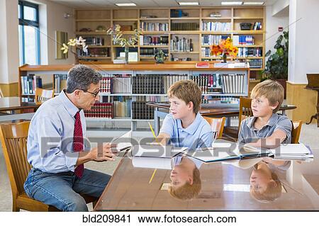 Teacher and students working in library View Large Photo Image Stock Image - Teacher and students working in library. Fotosearch