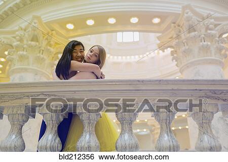 Teenage girls wearing gowns on ornate banister View Large Photo Image Stock Photograph - Teenage girls wearing gowns on ornate banister. Fotosearch