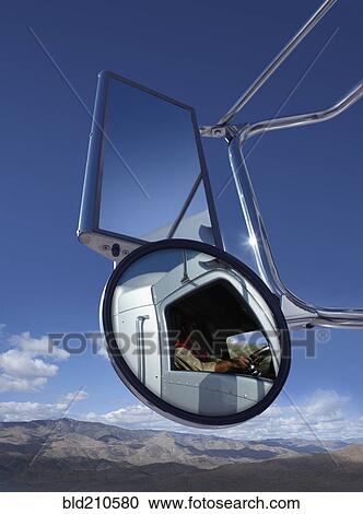 Stock Image - Trucker reflected in side mirror. Fotosearch