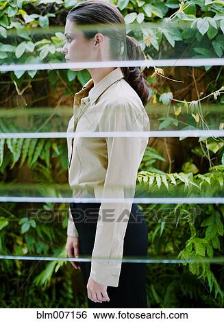 Woman behind window in greenhouse View Large Photo Image Stock Photograph - Woman behind window in greenhouse. Fotosearch