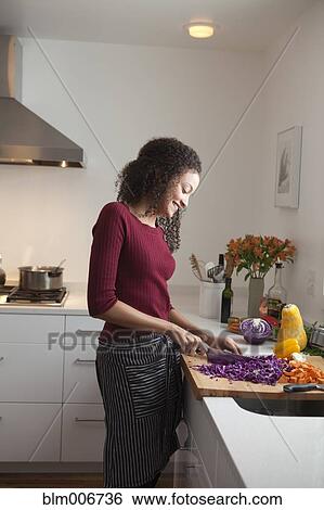 Woman cutting vegetables in kitchen View Large Photo Image Stock Photograph - Woman cutting vegetables in kitchen. Fotosearch