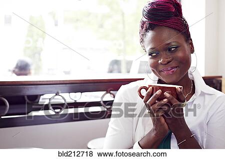 Stock Photo - Woman drinking cup of coffee in cafe. Fotosearch