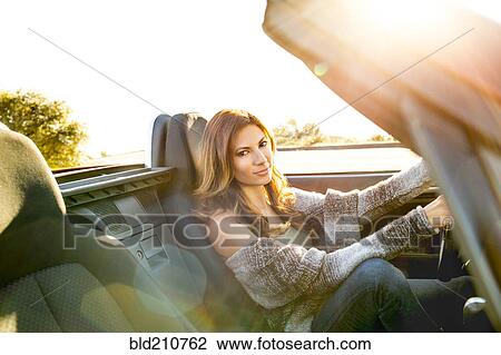 Woman driving convertible at sunset View Large Photo Image Stock Image - Woman driving convertible at sunset. Fotosearch