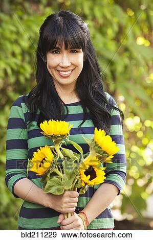 Stock Photo - Woman holding bouquet of sunflowers. Fotosearch