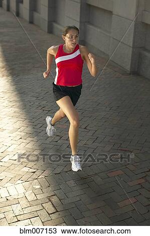 Woman jogging on sidewalk View Large Photo Image Stock Image - Woman jogging on sidewalk. Fotosearch