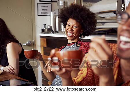Stock Image - Woman laughing in cafe. Fotosearch