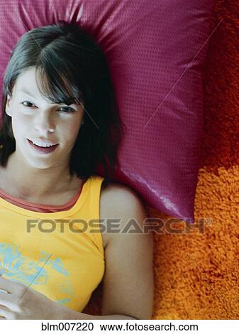 Woman laying on pillow on floor View Large Photo Image Stock Image - Woman laying on pillow on floor. Fotosearch