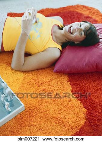 Woman laying on pillow on floor View Large Photo Image Stock Image - Woman laying on pillow on floor. Fotosearch