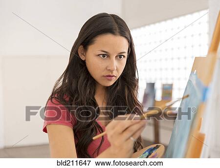 Woman painting at easel View Large Photo Image Stock Photo - Woman painting at easel. Fotosearch