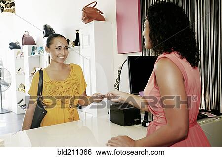 Woman paying with credit card in shoe store View Large Photo Image Stock Photograph - Woman paying with credit card in shoe store. Fotosearch