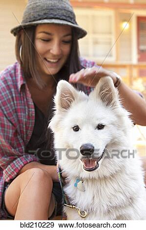 Stock Photo - Woman petting dog outdoors. Fotosearch