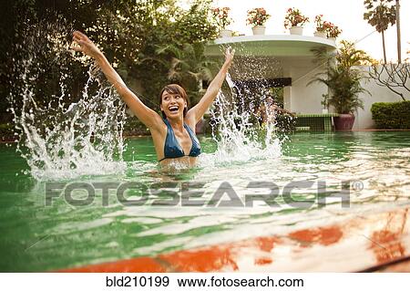 Woman playing in swimming pool View Large Photo Image Stock Photo - Woman playing in swimming pool. Fotosearch
