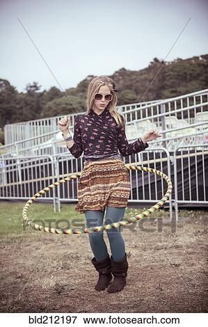 Stock Photo - Woman playing with hula hoop at festival. Fotosearch