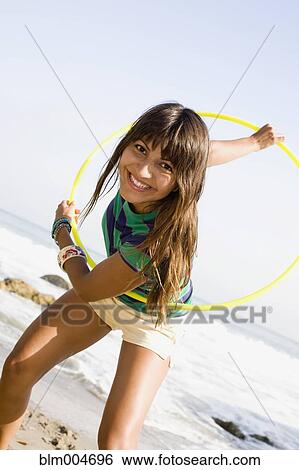 Woman playing with hula hoop on beach View Large Photo Image Stock Photograph - Woman playing with hula hoop on beach. Fotosearch