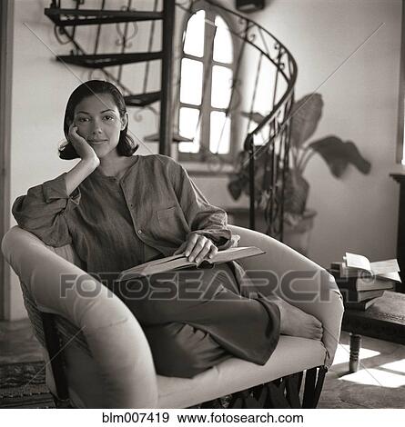 Woman relaxing in chair and reading book View Large Photo Image Stock Photo - Woman relaxing in chair and reading book. Fotosearch