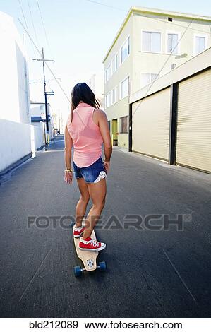 Woman riding longboard on city street View Large Photo Image Stock Photo - Woman riding longboard on city street. Fotosearch