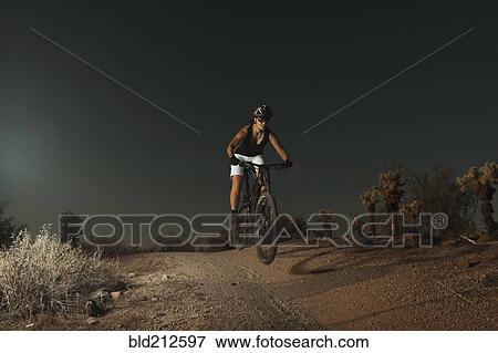 Woman riding mountain bike in desert View Large Photo Image Stock Photo - Woman riding mountain bike in desert. Fotosearch