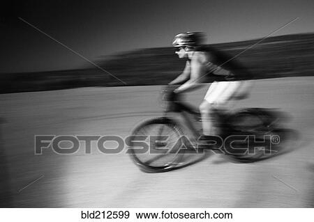 Stock Photo - Woman riding mountain bike in desert. Fotosearch