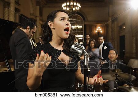 Stock Image - Woman singing in nightclub. Fotosearch
