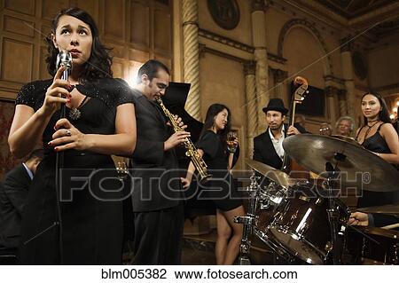 Stock Image - Woman singing in nightclub. Fotosearch