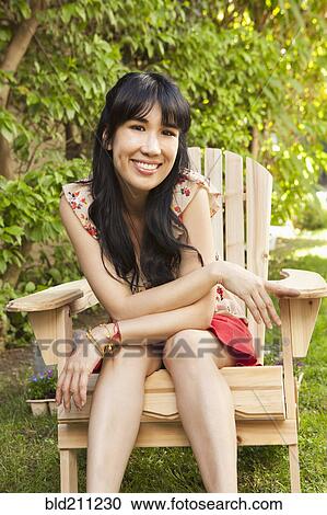 Woman sitting in chair outdoors View Large Photo Image Stock Image - Woman sitting in chair outdoors. Fotosearch