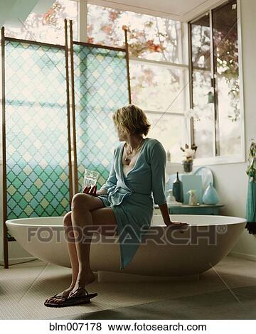 Woman sitting on edge of bathtub View Large Photo Image Stock Photo - Woman sitting on edge of bathtub. Fotosearch