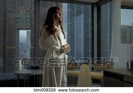 Stock Photo - Woman standing in bathrobe. Fotosearch