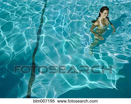 Stock Photography - Woman standing in swimming pool. Fotosearch