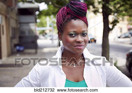 Stock Image - Woman standing on city street. Fotosearch