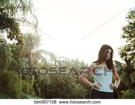 Woman standing outdoors with hands on hips View Large Photo Image Stock Photo - Woman standing outdoors with hands on hips. Fotosearch