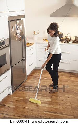 Woman sweeping kitchen View Large Photo Image Stock Image - Woman sweeping kitchen. Fotosearch