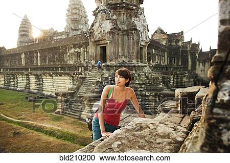 Stock Image - Woman visiting ancient temple, Angkor, Siem Reap, Cambodia. Fotosearch