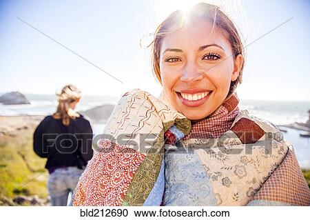 Stock Image - Woman wrapped in blanket on rural hillside. Fotosearch